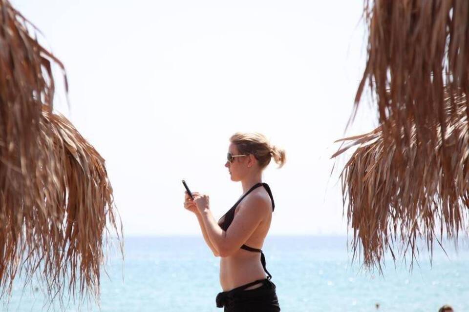 Mit dem Handy am Strand