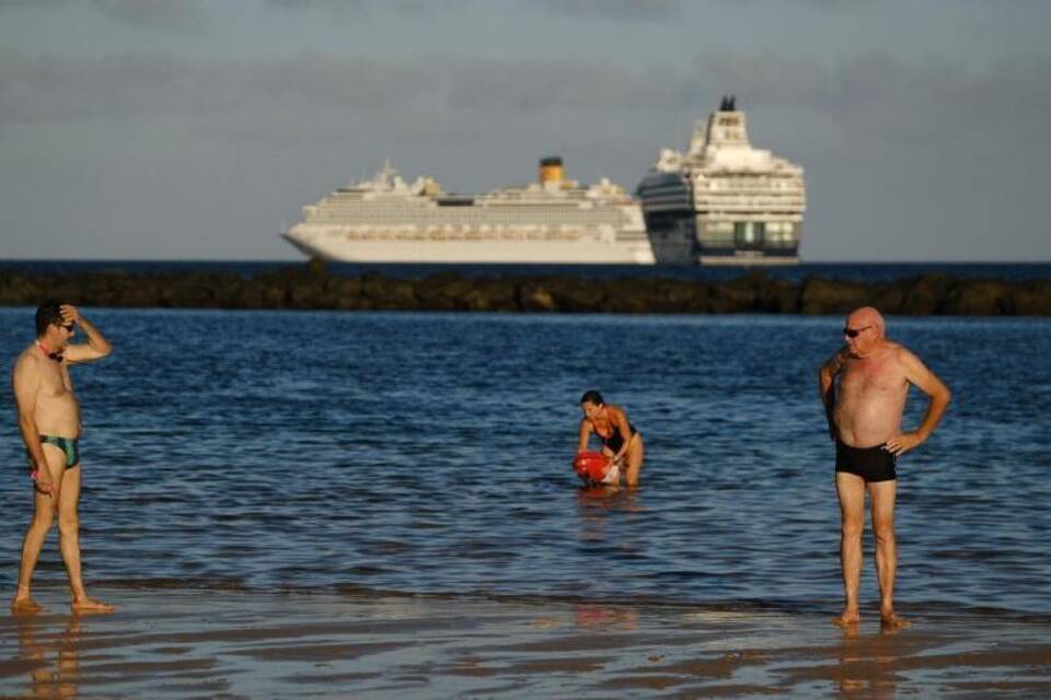 Menschen stehen im Wasser am Strand