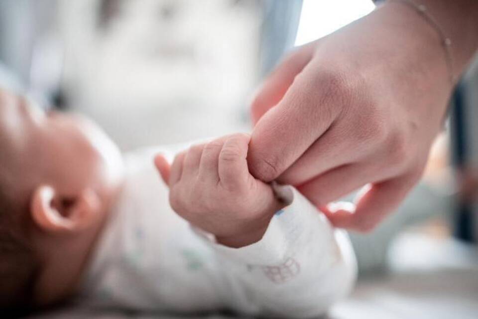 Ein Baby und eine Hand