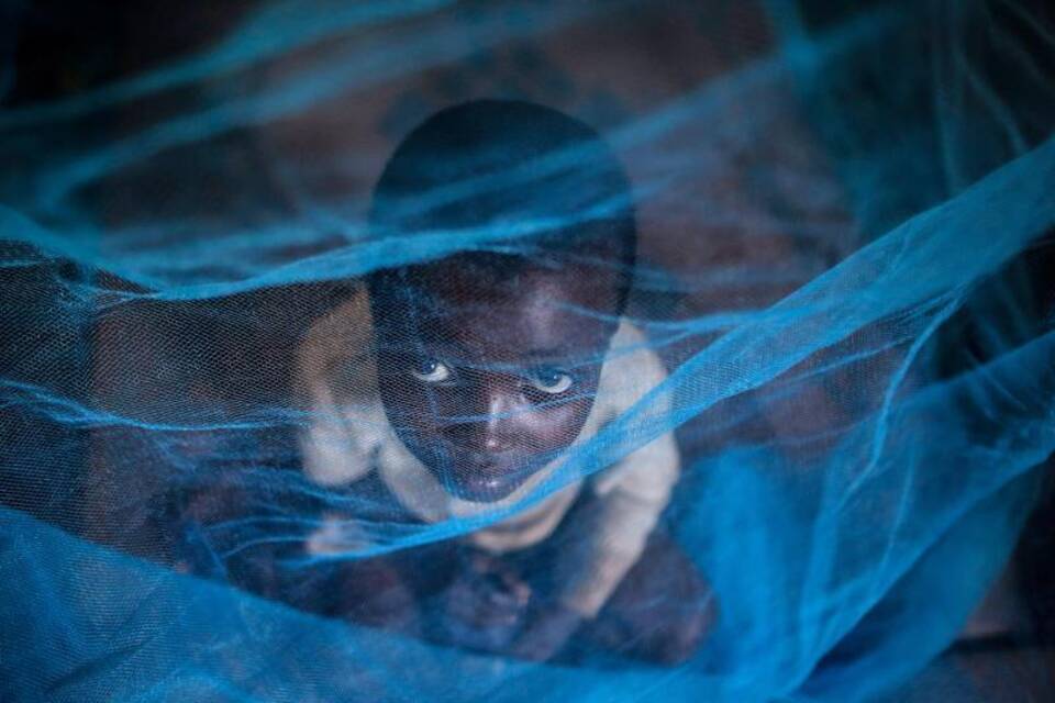 Kind unter einem Mückennetz