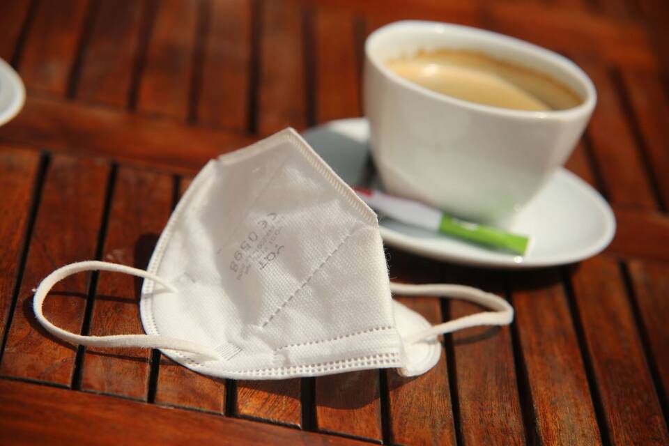 Maske auf Café-Tisch Maske auf Café-Tisch