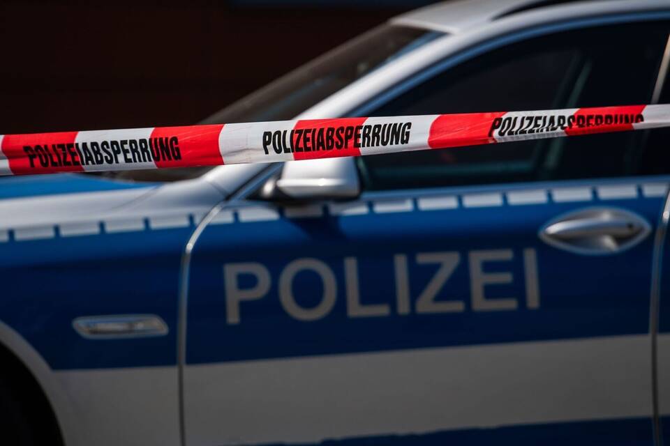 Ein Polizeiauto steht hinter einem Absperrband