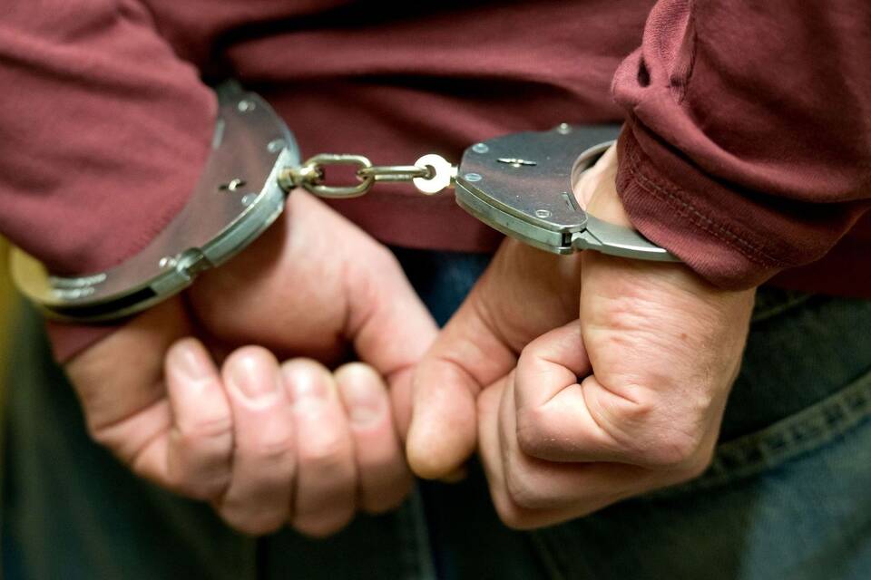 Ein Mann trägt Handschellen Ein Mann trägt Handschellen