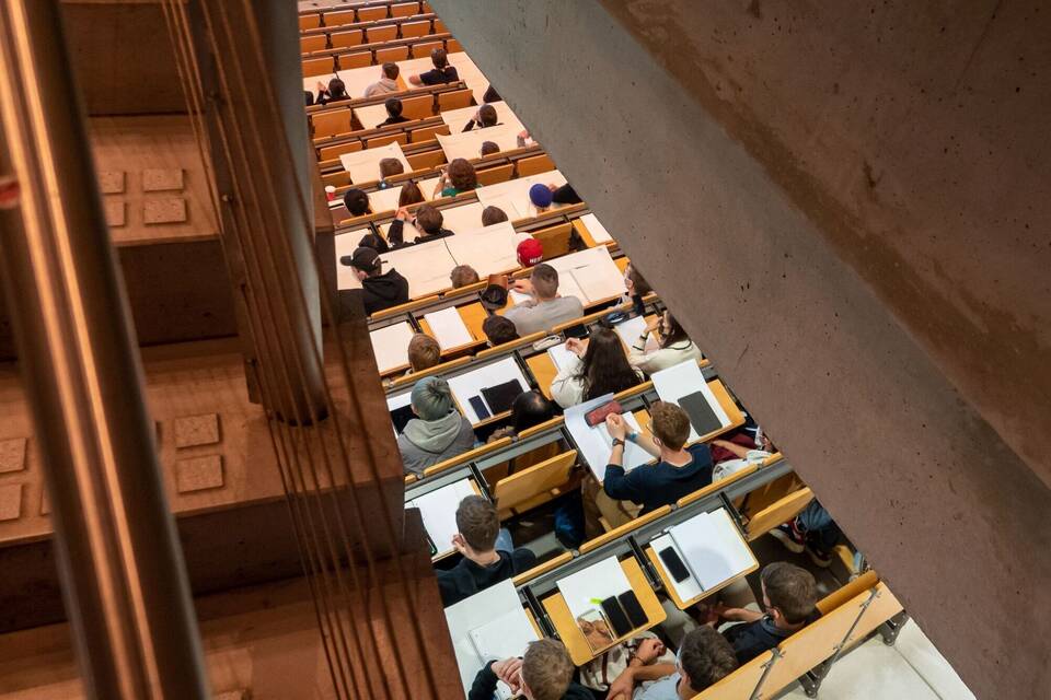 Studierende nehmen in einem Hörsaal an einer Vorlesung teil