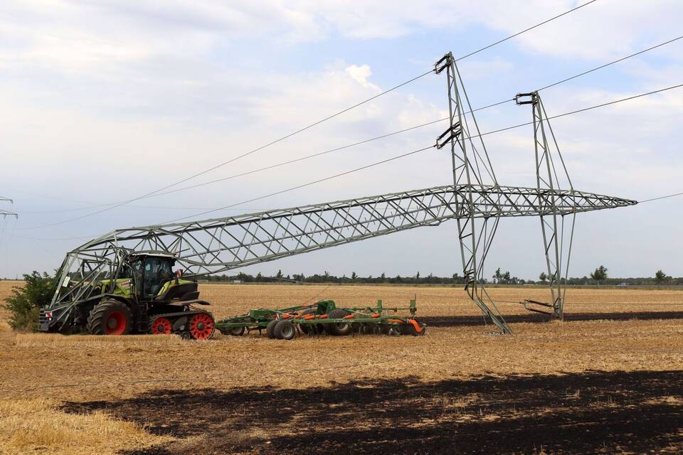 Landwirt fährt mit Traktor Mast um