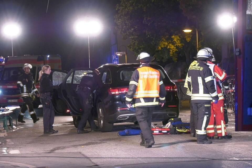 Auto fährt in Gruppe Feiernder Auto fährt in Gruppe Feiernder