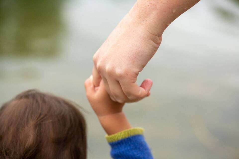 Mutter hält Kind an der Hand Mutter hält Kind an der Hand