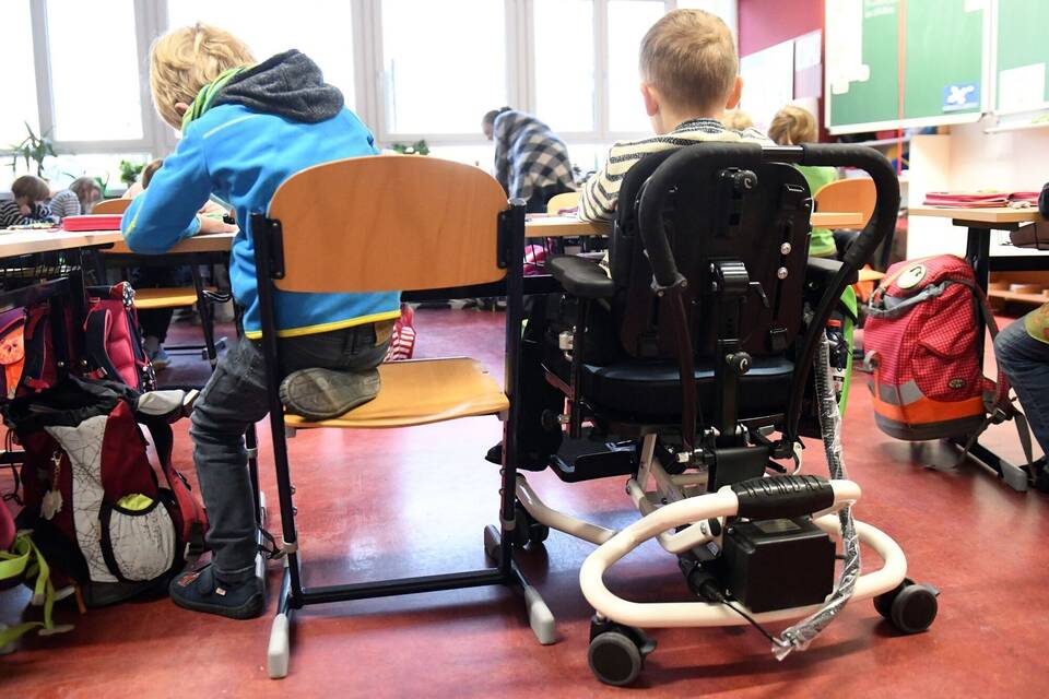 Ein Kind im Rollstuhl sitzt in einer Grundschule in Brandenburg