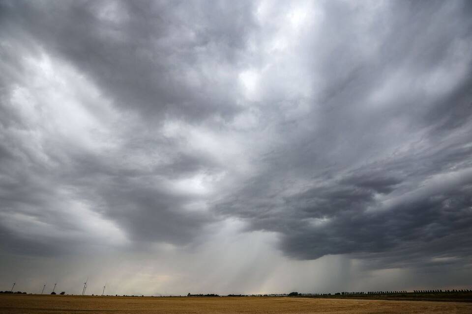 Regenwolken über einem Feld Regenwolken über einem Feld