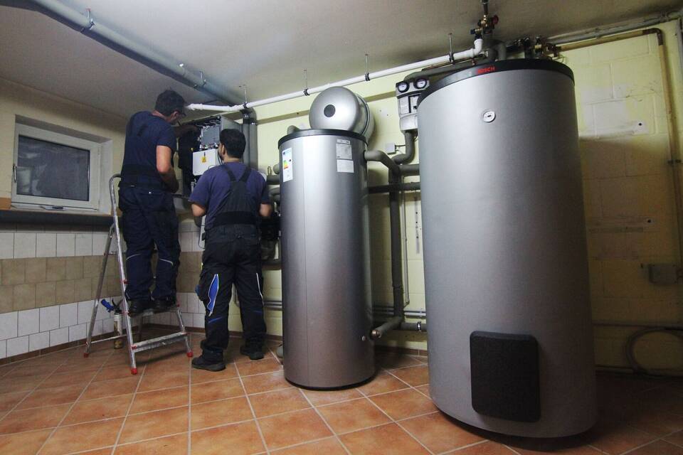 Handwerker stellen eine Wärmepumpe ein Handwerker stellen eine Wärmepumpe ein
