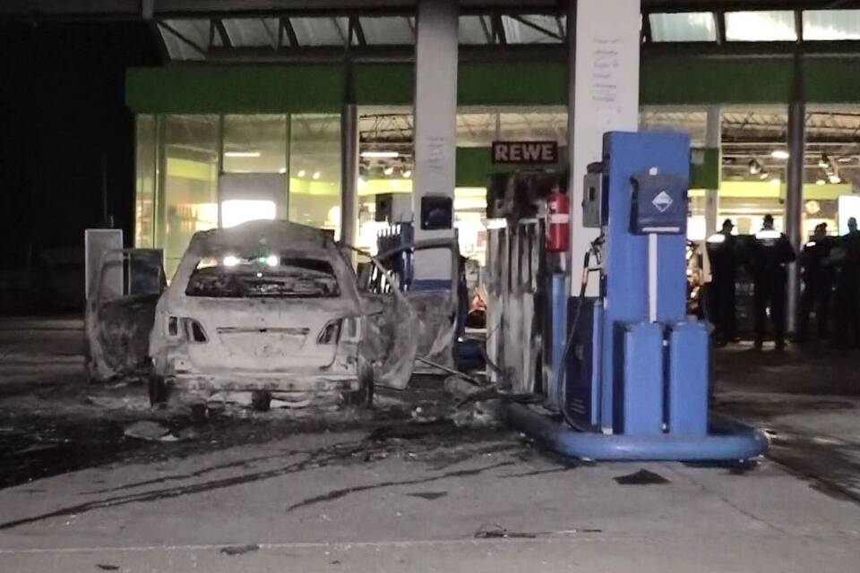 Mann fährt brennendes Auto an Tankstelle