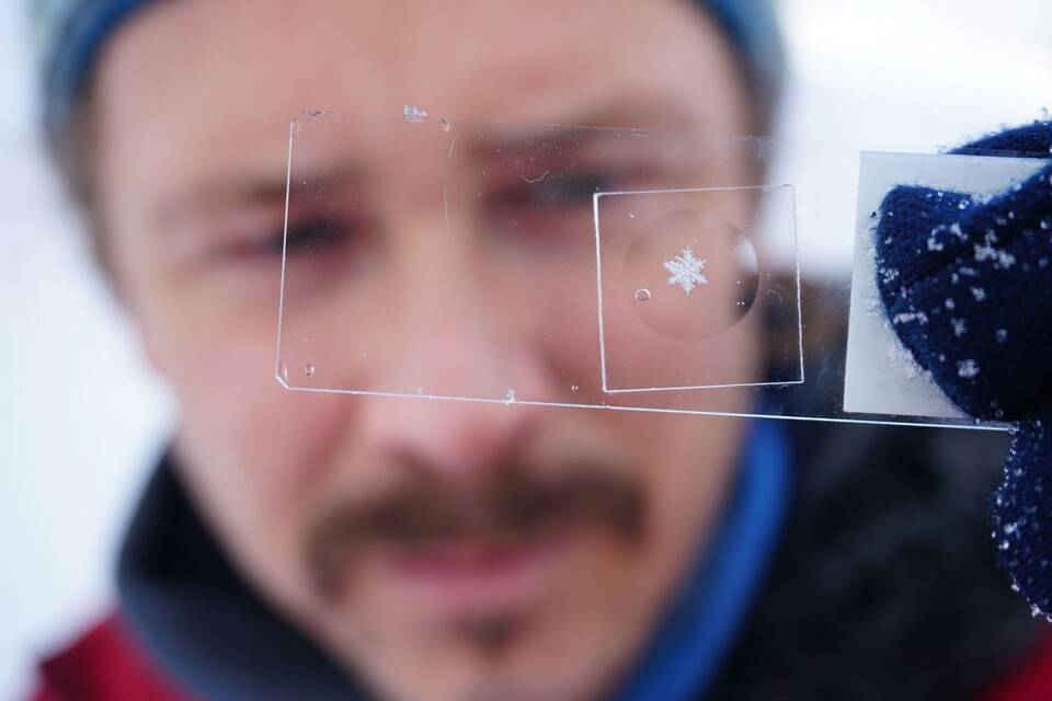 Paar verewigt Schneeflocken hinter Glas