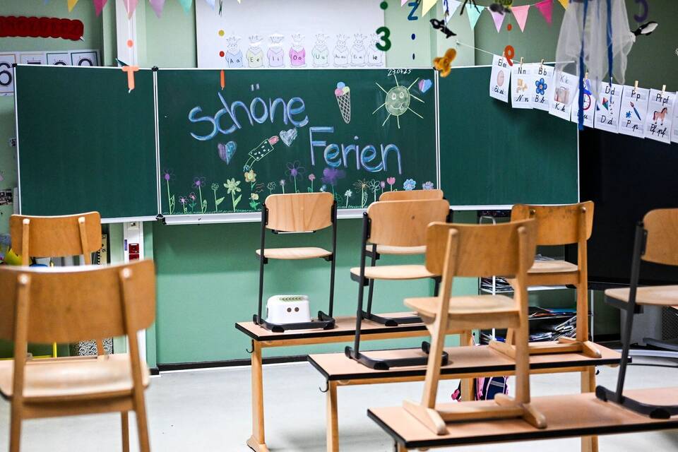 Hochgestellte Stühle und eine bemalte Tafel am letzten Schultag Hochgestellte Stühle und eine bemalte Tafel am letzten Schultag
