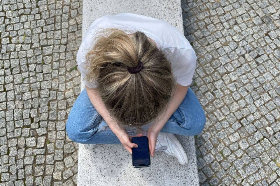Eine Frau schaut auf ihr Smartphone