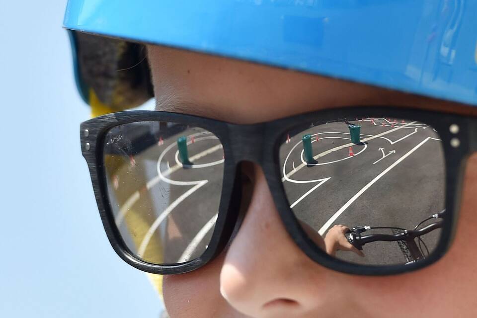 Ein Junge trägt eine Sonnenbrille auf einem Fahrrad-Parcours Ein Junge trägt eine Sonnenbrille auf einem Fahrrad-Parcours