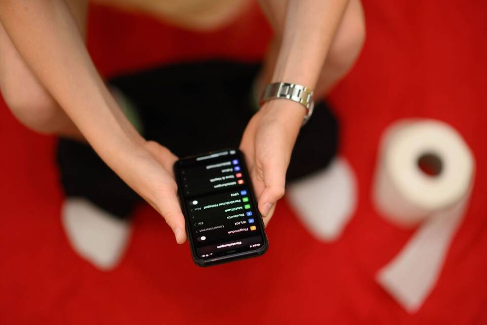 Mit Smartphone auf der Toilette Mit Smartphone auf der Toilette