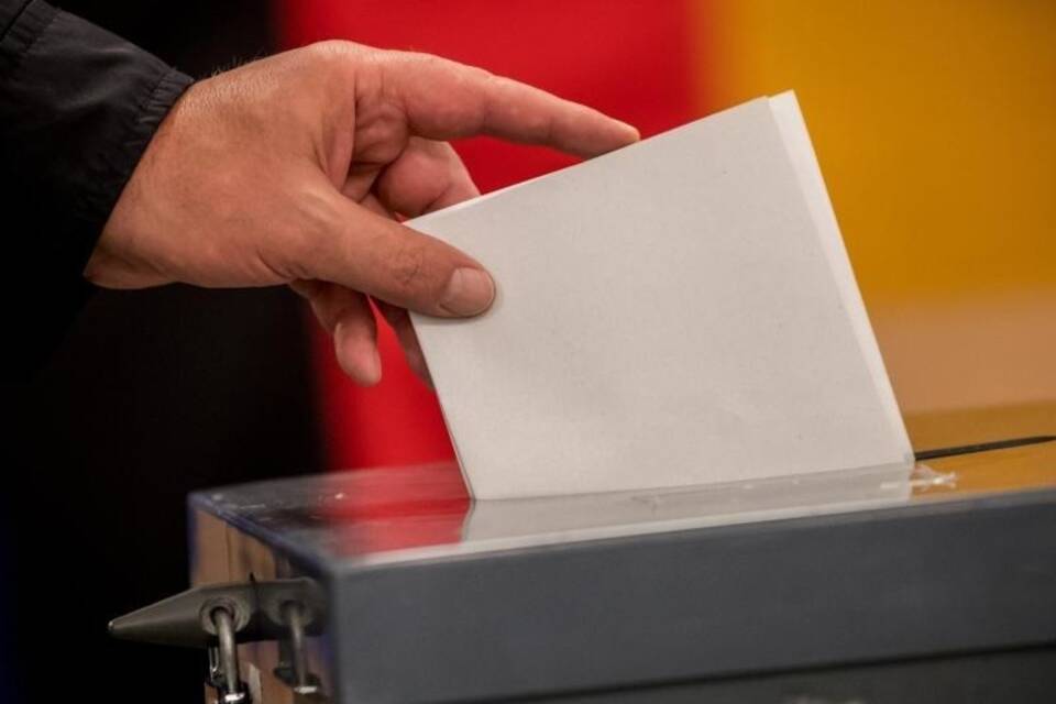 Wähler wirft Stimmzettel in Wahlurne