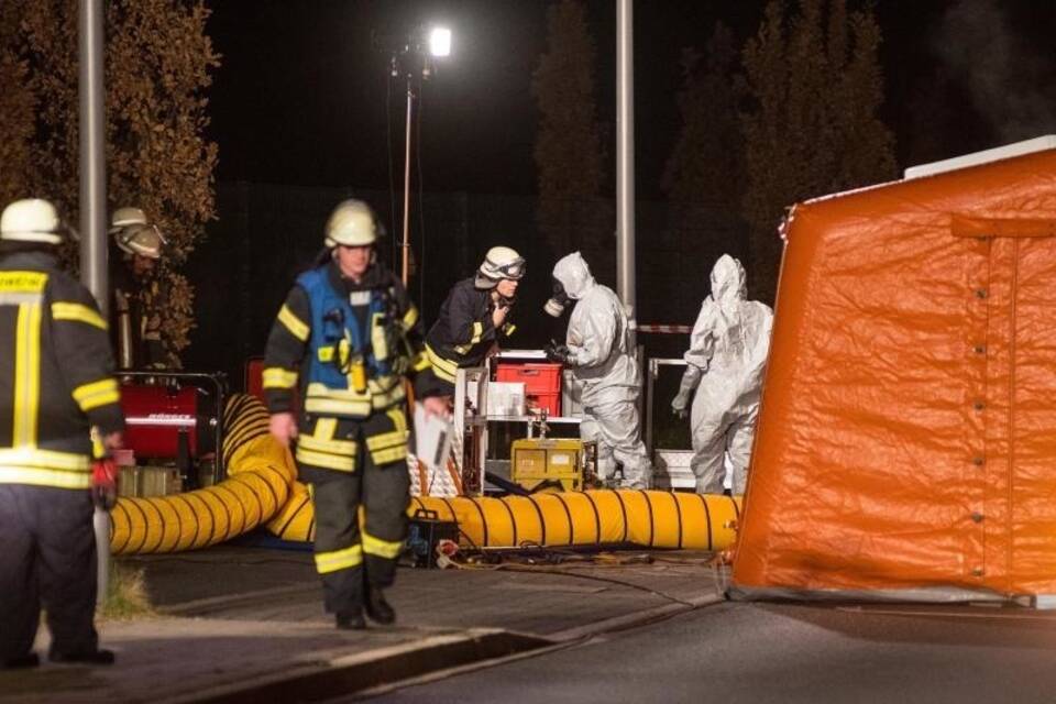 Feuerwehrleute sperren Gefahrenbereich ab