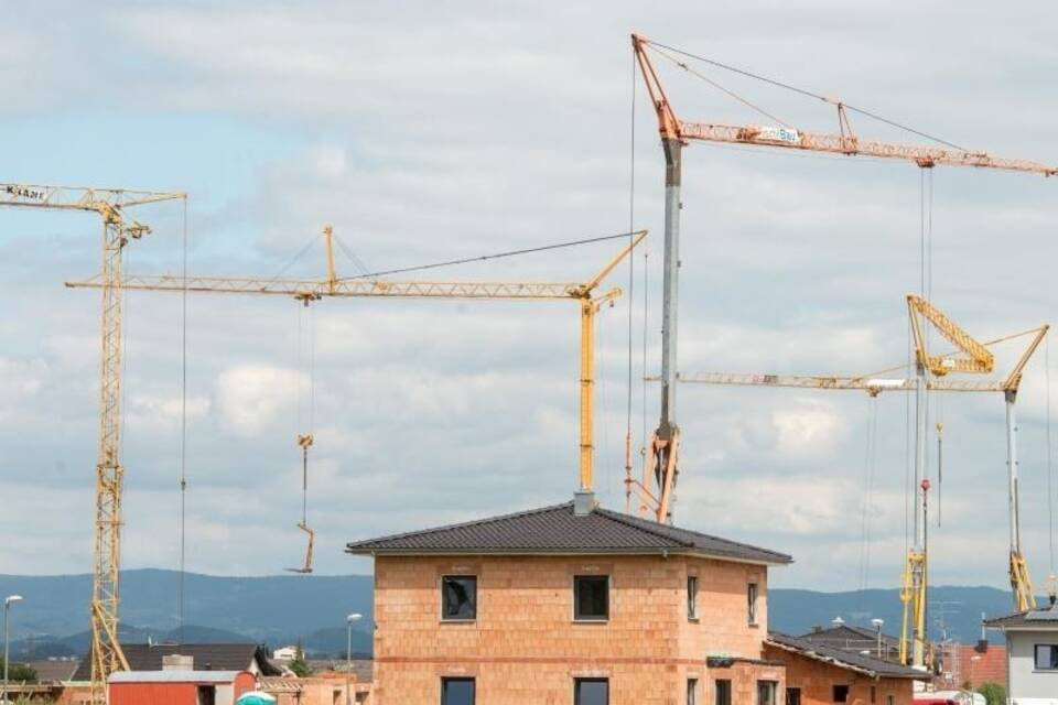 Baukräne in einer Neubausiedlung