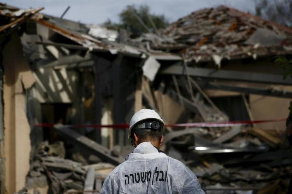 Polizist inspiziert zerstörtes Haus