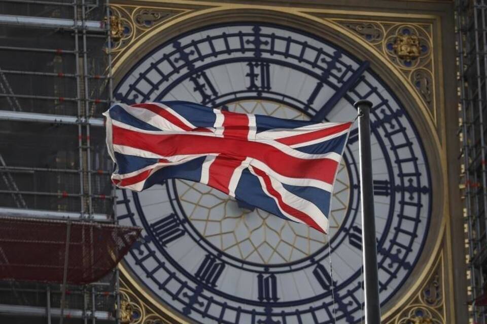 Der Union Jack weht vor dem Zifferblatt des Queen Elizabeth Tower Der Union Jack weht vor dem Zifferblatt des Queen Elizabeth Tower