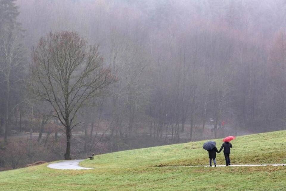 Spaziergänger sind an einem trüben Wintertag unterwegs Spaziergänger sind an einem trüben Wintertag unterwegs