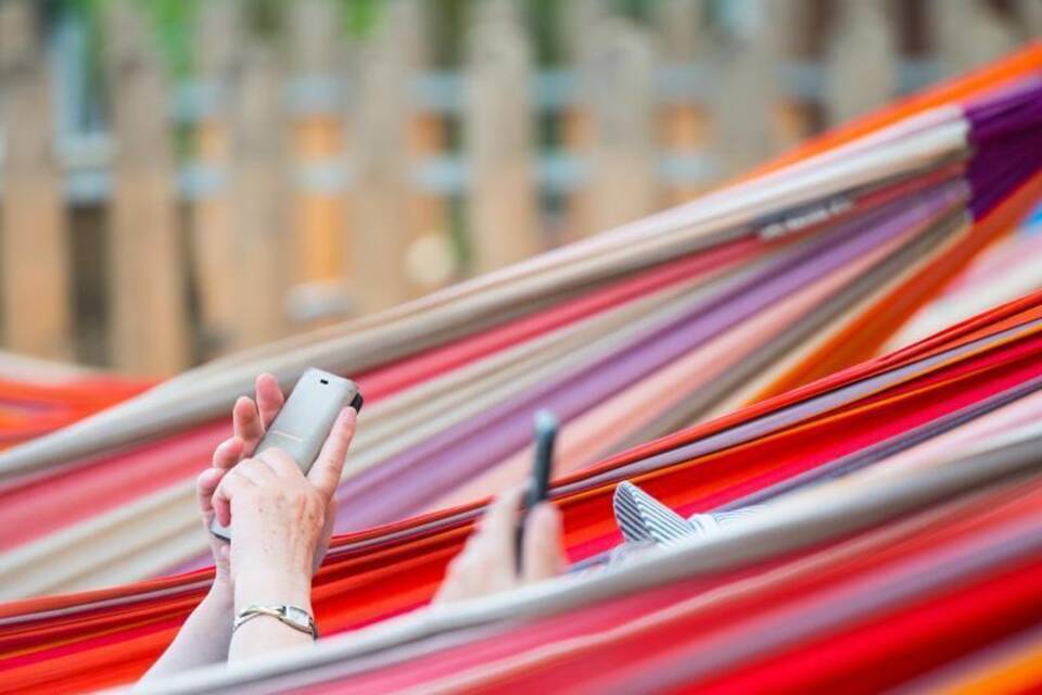 Frauen in Hängematten bedienen Smartphone Frauen in Hängematten bedienen Smartphone